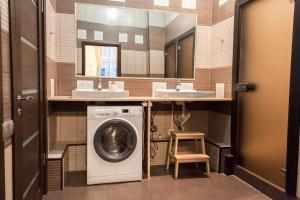 a bathroom with a washing machine and two sinks at Hostel Udacha in Saint Petersburg
