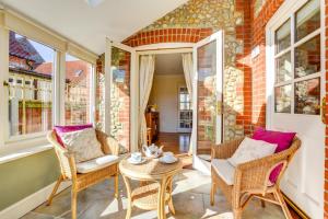 - une terrasse couverte avec 2 chaises et une table dans l'établissement Mallard Cottage, à Blakeney