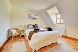 une chambre avec un lit et une chaise dans l'établissement Mallard Cottage, à Blakeney