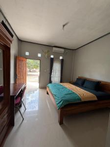 a bedroom with a bed and a desk in it at Maluk kost Tika HomeStay in Maluk