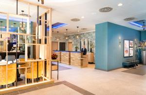 a store with blue walls and wooden furniture at Leonardo Hotel Hamburg Altona in Hamburg