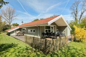 a small green house with a wooden deck at 3629-Nexo-Myrevej-14 in Neksø