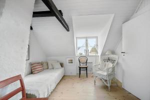 una sala de estar con un sofá y una silla en 5585-Svaneke-Helgolandsgade-7-B, en Svaneke