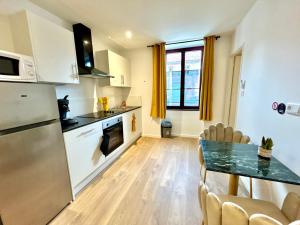 eine Küche und ein Esszimmer mit Tisch und Kühlschrank in der Unterkunft L'évasion Ansoise in Anse