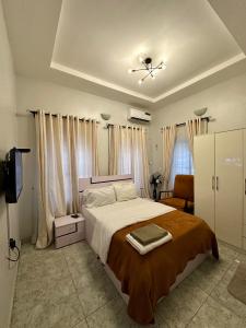 a bedroom with a large bed and a tv at Home from Home Lekki - 2 Bedroom Idado Lekki in Lagos