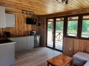 a kitchen with wooden walls and wooden flooring in a cabin at Chatka Mała Sowa - Stara Rzeka in Stara Rzeka