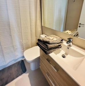 a bathroom with a sink and a toilet and a mirror at Arauco Premium Suite in Santiago