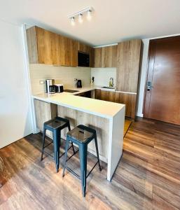 a kitchen with a counter and two stools at Arauco Premium Suite in Santiago +290 photos
