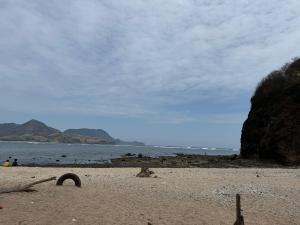a sandy beach with a view of the ocean at Maluk kost Tika HomeStay in Maluk +3 photos