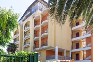 un edificio de apartamentos con balcones y una palmera en Residence Palazzo Sayonara en Tortoreto