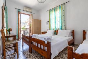 a bedroom with two beds and a window at Fotini Rooms in Skopelos Town
