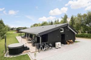 a black house with a deck with a bike on it at OH438-Hadsund-Sellegaarde-Vest-16-A in Hadsund