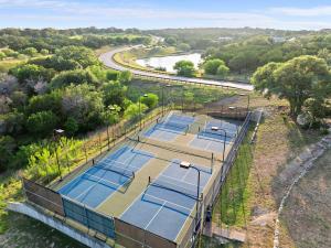 Una vista aérea de cuatro canchas de tenis con una autopista en Luxe 3BR Lake Escape - BBQ Firepit & Pickleball, en Edgewater Beach