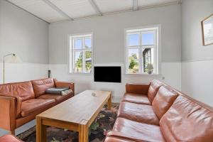 a living room with two leather couches and a table at 6746-Hasle-Krakvej-3 in Hasle