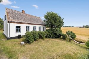 a small white house on a field with bushes at 6746-Hasle-Krakvej-3 in Hasle