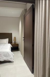 - une chambre avec un lit et une porte coulissante dans l'établissement جناح راڤينا الراقي, à Riyad