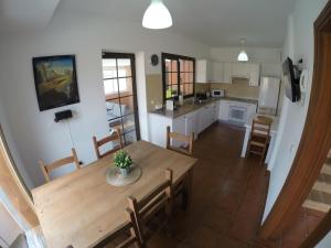 a kitchen and dining room with a wooden table and chairs at Casa Macu in Puerto del Rosario