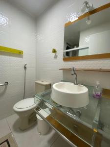 a bathroom with a sink and a toilet at Pé na areia, Prainha in Arraial do Cabo