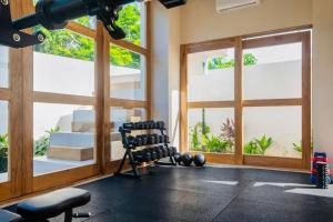 una habitación con un gimnasio con banco y ventanas en Casa Taco Champagne, en Brisas de Zicatela