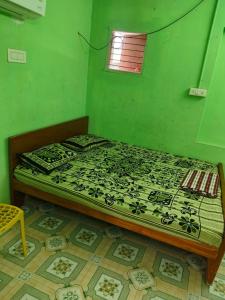 a bed in a room with a green wall at shan mantion in Vellore