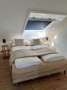 a bedroom with a large bed with a skylight at FeWo Rose 52 Travemünde in Travemünde
