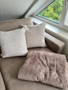a couch with two pillows and a blanket on it at FeWo Rose 52 Travemünde in Travemünde