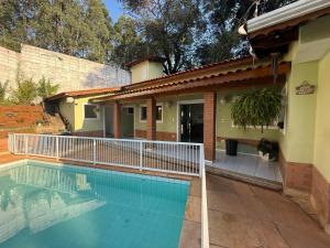 a swimming pool in front of a house at Chácara 3 quartos com piscina e churrasqueira in Itatiba
