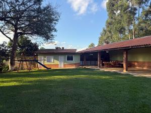 a yard with a house and a playground at Chácara 3 quartos com piscina e churrasqueira in Itatiba