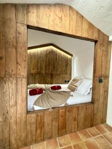 a bedroom with a large mirror in a wooden wall at Casita Barranco del agua in Yaiza