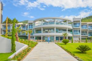 a woman walking down a sidewalk in front of a large building at Thassos Imperial Resort in Skala Rachoniou