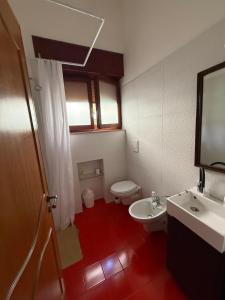 a bathroom with a white toilet and a sink at villa raffaela lido silvana marina di pulsano fatamorgana in Pulsano