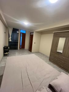 Una habitación vacía con una cama grande y una cómoda. en Departamento de Estreno Amplio y Confortable, en Ayacucho