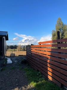 a wooden fence in front of a barn at Cómoda casa cercana a Castro in Castro +15 photos