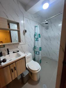 Un baño con inodoro, lavabo y ducha. en Departamento de Estreno Amplio y Confortable, en Ayacucho 11 fotos más