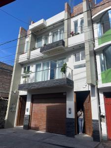 una mujer parada en la puerta de un edificio en Departamento de Estreno Amplio y Confortable, en Ayacucho