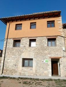 a large stone building with windows on the side at Apartamentos de Turismo Rural La Rocha in Fortanete