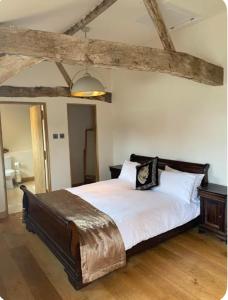 a bedroom with a large bed with white sheets at Tranquil detached barns in Sherborne St John in Sherborne Saint John