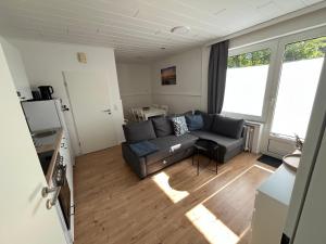 a living room with a couch and two windows at Vier Nordlichter Erdgeschosswohnung mit Terrasse und Garten in Bensersiel +7 photos