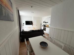 a living room with a table and a couch at Vier Nordlichter Erdgeschosswohnung mit Terrasse und Garten in Bensersiel