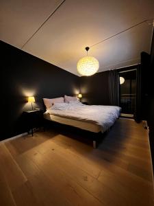 a bedroom with a bed and a chandelier at Large and airy penthouse, including parking! in Sandnes