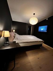 a bedroom with a bed and a desk and a television at Large and airy penthouse, including parking! in Sandnes +7 photos