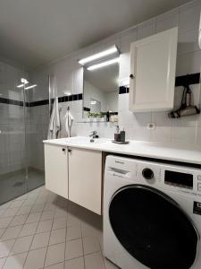 a kitchen with a washing machine and a sink at Large and airy penthouse, including parking! in Sandnes