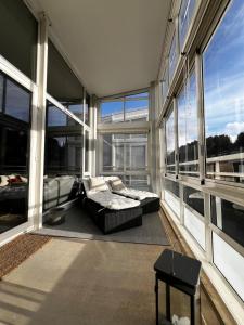 a room with a bed and a couch in a room with windows at Large and airy penthouse, including parking! in Sandnes
