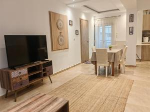 a living room with a table and a flat screen tv at Spitaki in Kefalos