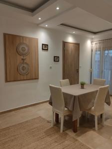 a dining room with a white table and chairs at Spitaki in Kefalos +4 photos