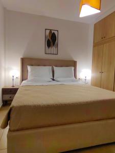 a bedroom with a large bed with two lamps at Spitaki in Kefalos +4 photos