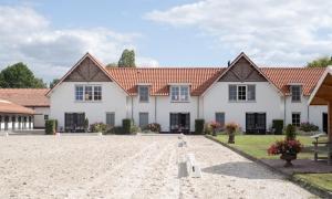 a large white house with red roof at Aparthotel Landgoed Culitsrode in Hooge Mierde