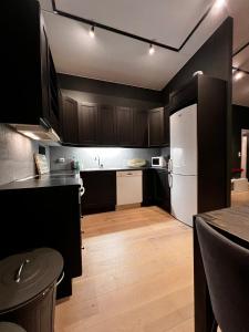 a kitchen with black cabinets and a white refrigerator at Large and airy penthouse, including parking! in Sandnes