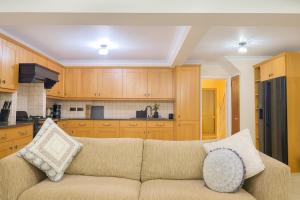 a living room with a couch and a kitchen at North London Holiday home, Driveway Parking, BBQ and Indoor Jacuzzi hot tub in Brimsdown Station