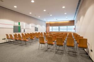 an empty lecture room with chairs and a podium at Leonardo Royal Hotel Barcelona Forum in Barcelona +113 photos